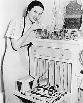 Young woman at her vanity applying lipstick photo