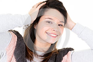 Young woman hide her hands in brunette head hairs and smile