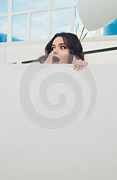 Young woman hiding in a carton box.