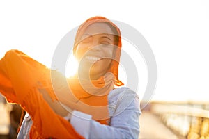 Young woman in hijab outdoors at sunset