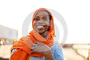 Young woman in hijab outdoors at sunset