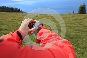 Hiker checking the altimeter on sports watch at mountain peak
