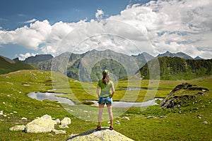 Young woman hiker enjoy the view on mountain peak cliff and river at sunny day