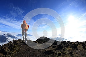 Young woman hiker hiking on mountain peak