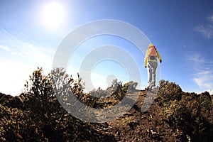 Young woman hiker hiking on mountain peak