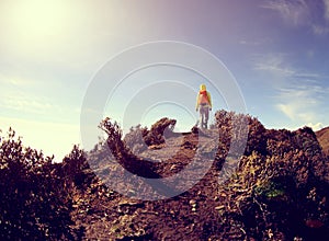 Young woman hiker hiking on mountain peak