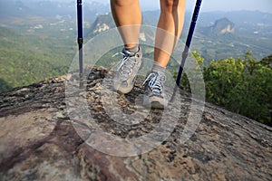 Young woman hiker legs on mountain peak