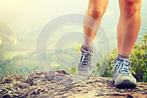 Young woman hiker legs on mountain peak