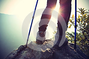 Young woman hiker legs on mountain peak