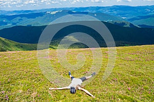 Young woman hiker lies on the top of hill and Enjoy beautiful mountain valley view