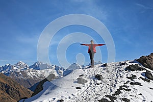 Young woman hiker on the mountain top against blue sky