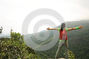 Young woman hiker open arms outdoor