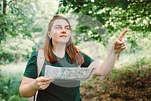 Young woman hiker reading map hiking trip looking to find place to go,, having fun and relaxing while spending summer