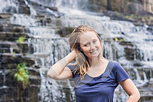 Young woman hiker, tourist on the background of Amazing Pongour Waterfall is famous and most beautiful of fall in