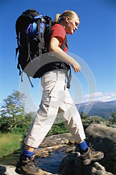 Young woman hiking across a river