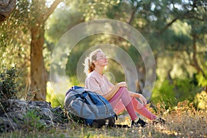 Young woman hiking in countryside. Girl resting under the tree. Concepts of adventure, extreme survival, orienteering. Single