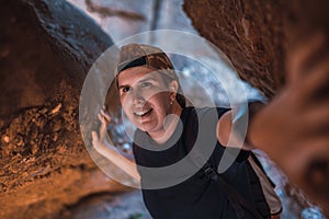 young woman hiking, exploring the entrance of a cave. woman on vacation. young woman hiking in nature.