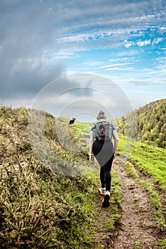 Young woman hiking in the mountains of the French Basque Country with their Border Collie