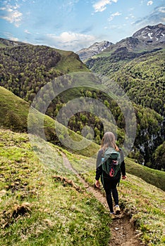 Young woman hiking in the mountains of the French Basque Country with their Border Collie