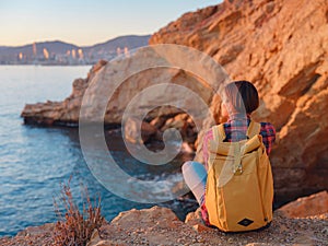 Young woman hiking on rocky beach in Spain, Benidorm