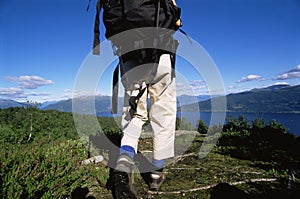 Young woman hiking towards a lake