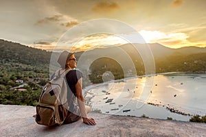 Young woman hipster traveler enjoying the view, sunset on the se