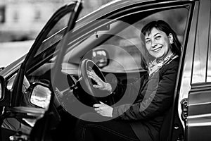 A young woman in his new car. Black and white photography.