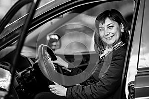 A young woman in his new car. Black and white photography.