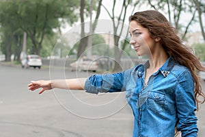 Young woman hitch-hiking in sity
