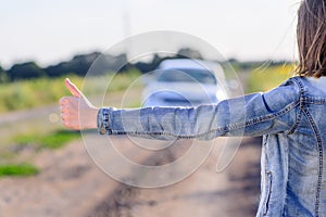 Young woman hitchhiking in the countryside