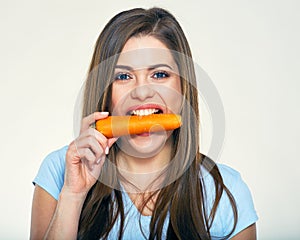 Young woman holdin carrot in teeth.