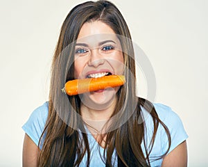 Young woman holdin carrot in teeth.