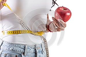 Young woman holding an apple and a measuring tape as a healthy lifestyle concept. Isolated background