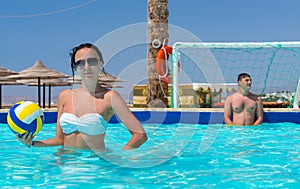 Young woman holding a ball while playing water polo