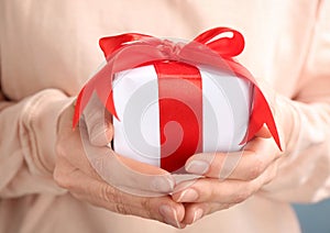 Young woman holding beautifully decorated gift box