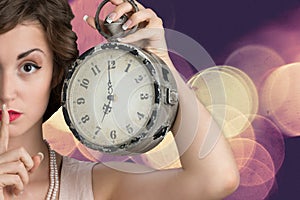 Young woman holding big clock