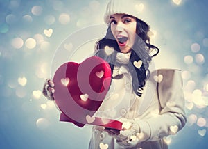 Young woman holding a big heart gift box