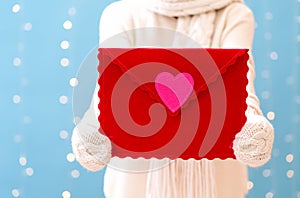 Young woman holding a big Valentine`s day envelope