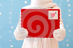 Young woman holding a big Valentine`s day envelope