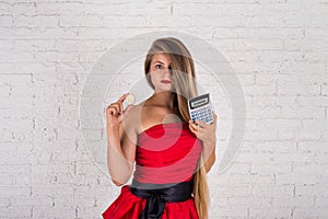 Young woman holding bitcoin and calculator