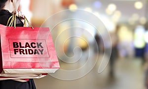 Young woman holding black friday shopping bag photo