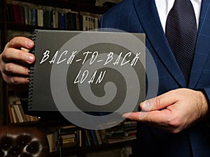 Young woman holding a blank card in hands. Conceptual photo about BACK-TO-BACK LOAN with written text