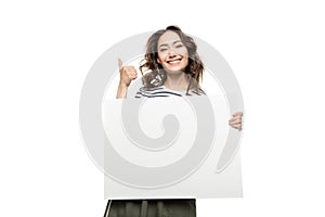 Young woman holding blank white card and showing thumb up