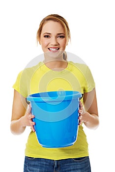 Young woman holding blue bucket.