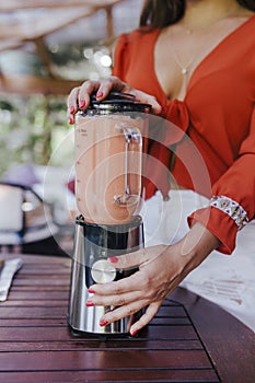 young woman holding a bowl of blackberries. preparing a healthy recipe of diverse fruits, watermelon, orange and blackberries.