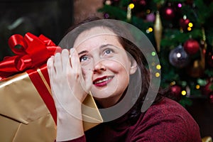 Young woman holding a box with a New Year gift