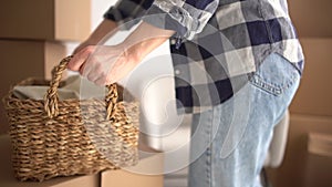 Young woman holding a box to move it to another site. Cheerful young girl carrying carton cardboard box. Moving into new