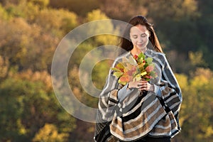 Young woman holding bunch of autumn leaves. Natural beauty. Fear of aging concept