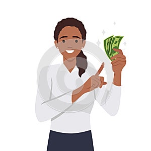 Young woman holding cash currency money in hand and pointing towards that