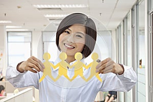 Young Woman Holding a Catena of Figures Cutted of Paper